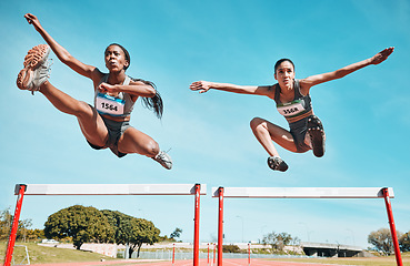 Image showing Sports, hurdles and team of women on track running in a race, marathon or competition in stadium. Fitness, workout and female athletes jumping with speed and energy for outdoor training or practice.