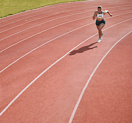 Image showing Woman, athlete and running on stadium in fitness, workout or cardio exercise for practice or training on track. Female person or runner in sport competition, performance or race in outdoor motivation