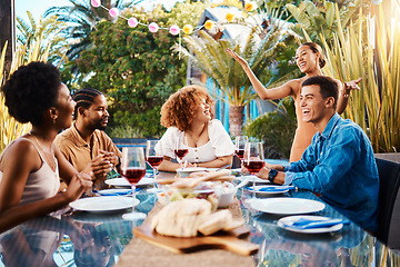 Image showing Friends, food and eating outdoor at a table for social gathering, happiness and holiday celebration. Diversity, men and women group at lunch, party or reunion with drinks in garden for fun and relax