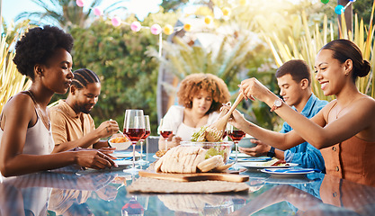 Image showing Friends at lunch, party in garden and happy event with diversity, food and wine for bonding together. Outdoor dinner, men and women at table, group of people eating with drinks in backyard in summer.