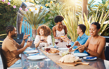 Image showing Group of friends at lunch in garden and talking at happy event with diversity, food and wine. Outdoor dinner, men and women in conversation at table, people eating with drinks in backyard together.