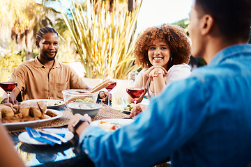 Image showing Happy, friends and lunch in a garden with conversation, eating and bonding at a table. Smile, laughing and diversity of a woman and men in a backyard with food, conversation or dinner together