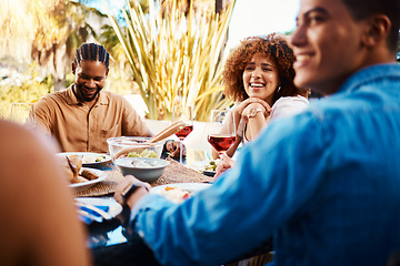 Image showing Happy, friends and lunch in a garden together for conversation, eating and bonding at a table. Smile, laughing and diversity of a woman and men in a backyard with food, conversation or dinner