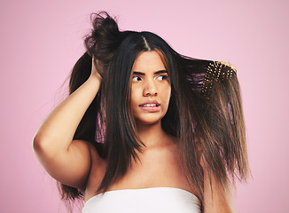 Image showing Woman, hair care and studio with brush, tangle and stress with frustrated face by pink background. Girl, model and anxiety with mistake, fail and thinking with beauty, cleaning and cosmetic crisis