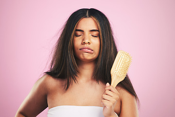 Image showing Hair care, frustrated and woman with brush ready for salon beauty treatment in a studio. Brushing, upset and Brazilian hairstyle growth with female model from Brazil with problem and pink background