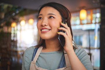 Image showing Restaurant, phone call and Asian woman for order, delivery and online food service in cafeteria. Coffee shop, small business and happy waitress, cafe barista or manager on smartphone in discussion