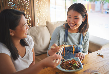 Image showing Chopsticks, restaurant and girl friends eating noodles and Asian cuisine at a cafe. Happy, hungry women and plate of food at a Japanese bar with friendship, smile and bonding from meal at a table