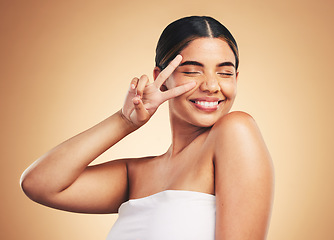 Image showing Woman, beauty and skincare with peace sign, studio and cosmetics with natural glow on face by background. Girl, model and happy with icon, emoji or facial change with melasma, healthy shine and clean