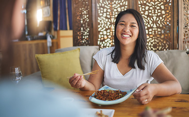 Image showing Asian, food and woman on restaurant date eating for dinner or lunch meal using chopsticks and feeling happy with smile. Plate, young and person enjoy Japanese cuisine, noodles or diet at a table