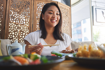 Image showing Asian, food and woman at a restaurant eating for dinner or lunch meal using chopsticks and feeling happy for nutrition. Plate, young and person enjoy Japanese cuisine, noodles or diet at a table