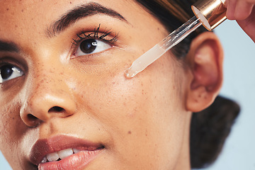 Image showing Woman, face oil and serum in studio for beauty of aesthetic skincare, dermatology and makeup on blue background. Closeup of model with dropper for facial cosmetics, hyaluronic acid and clean shine