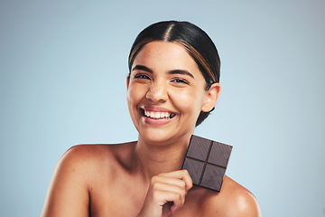 Image showing Portrait, chocolate and happy woman in studio with diet, craving or unhealthy luxury snack on grey background. Face, smile and lady model with candy bar, sugar and cocoa, addiction or diet temptation