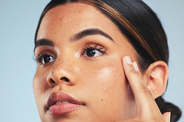 Image showing Thinking, skincare or woman with beauty, cosmetics or dermatology on a blue studio background. Person, idea or model with wellness, self care or healthy skin with makeup, hygiene or natural treatment