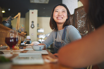 Image showing Happy, eating and friends at a restaurant for food, conversation or bonding together. Smile, excited and an Asian girl or women at a cafe for fine dining, talking and hungry at a table with people