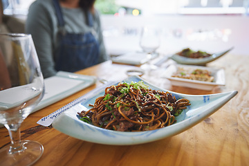 Image showing Plate, eating and noodles at a restaurant on a table for Chinese food at lunch. Closeup, health and Asian cuisine for dinner, hungry or a meal at a fine dining cafe for a traditional snack or supper