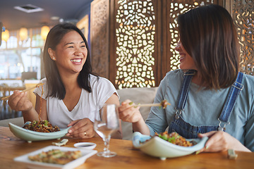 Image showing Chopsticks, girl friends and funny joke with restaurant food, noodles and cafe happy from bonding. Asian women, eating and plate together with smile at a table hungry with lunch at Japanese bar