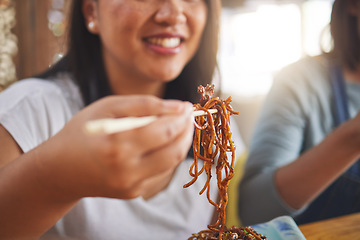 Image showing Asian, noodles and woman at a restaurant eating for dinner or lunch meal using chopsticks and happy for ramen nutrition. Plate, young and person enjoy Japanese cuisine, food or diet at a table