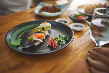 Image showing Plate, table and sushi with a person at a restaurant for fish, lunch or seafood dinner. Closeup, hungry and people at a cafe for fine dining, Chinese food or eating Asian cuisine for a meal together