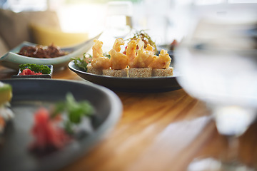 Image showing Sushi restaurant, catering and table in closeup for service, lunch or dinner with wine, glass and fish plate. Japanese cuisine, menu and seafood in diner, cafe or luxury for health, nutrition or diet