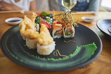 Image showing Japanese, sushi and food at a restaurant for dinner or lunch meal at a healthy Asian cafe on table. Plate, cuisine and fine dining takeaway or seafood from a Salmon menu for diet or nutrition