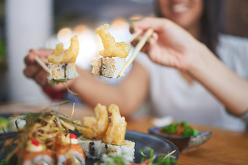 Image showing Chopsticks, girl friends hands and shrimp sushi at a table with Japanese cuisine food at restaurant. Young women, eating and tempura prawn with fish for lunch and meal on a plate with a smile