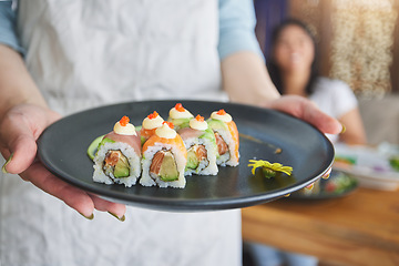 Image showing Restaurant, hands and closeup of sushi on a plate for luxury, healthy and authentic Asian cuisine. Platter, fine dining and zoom of a Japanese meal for lunch, dinner or supper at a traditional cafe.