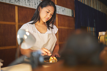 Image showing Chinese food, recipe and an asian woman in a sushi restaurant to serve a traditional meal for nutrition. Kitchen, cooking or preparation with a young female chef in an eatery for fine dining cuisine