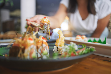 Image showing Hand, closeup and chopsticks in sushi restaurant for diet, fine dining and party with catering platter. Person, healthy fish and salmon with culture, traditional or fast food in diner, bar or store