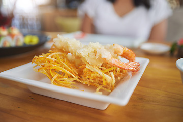 Image showing Food, sushi and cuisine on a table in a restaurant for a traditional asian dish or meal closeup. Seafood, fine dining and shrimp tempura on a plate in a chinese eatery for hunger or nutrition