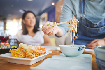 Image showing Hand, ramen and chopsticks for Chinese food with a woman closeup in a restaurant to eat a meal. Soup, noodles and cuisine with a customer in an eatery for nutrition or traditional Japanese dinner