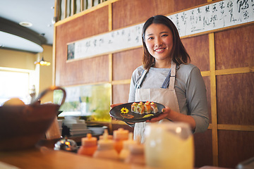 Image showing Sushi restaurant, portrait and female waitress with a plate for serving a food order with a smile. Happy, lunch and young Asian server with Japanese recipe or meal at a traditional cuisine cafe.