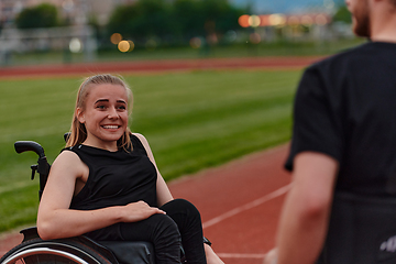 Image showing A woman with disability in a wheelchair talking with friend after training on the marathon course