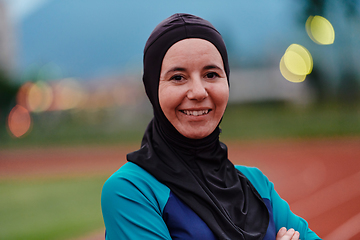 Image showing A Muslim woman with a burqa, an Islamic sportswoman resting after a vigorous training session on the marathon course. A hijab woman is preparing for a marathon competition