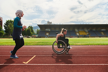 Image showing A Muslim woman in a burqa running together with a woman in a wheelchair on the marathon course, preparing for future competitions.