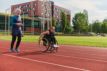 Image showing A Muslim woman in a burqa running together with a woman in a wheelchair on the marathon course, preparing for future competitions.