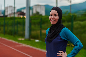 Image showing A Muslim woman with a burqa, an Islamic sportswoman resting after a vigorous training session on the marathon course. A hijab woman is preparing for a marathon competition