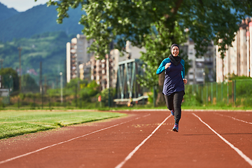 Image showing A muslim woman in a burqa sports muslim clothes running on a marathon course and preparing for upcoming competitions