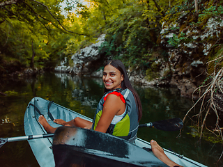 Image showing A smiling woman enjoying a relaxing kayak ride with a friend while exploring river canyons