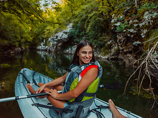 Image showing A smiling woman enjoying a relaxing kayak ride with a friend while exploring river canyons