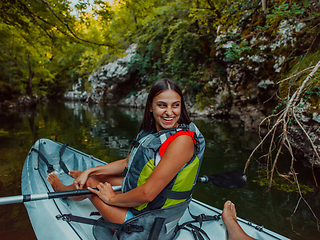 Image showing A smiling woman enjoying a relaxing kayak ride with a friend while exploring river canyons