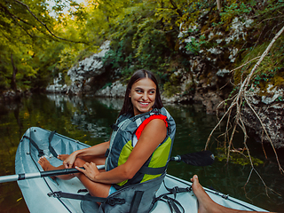 Image showing A smiling woman enjoying a relaxing kayak ride with a friend while exploring river canyons