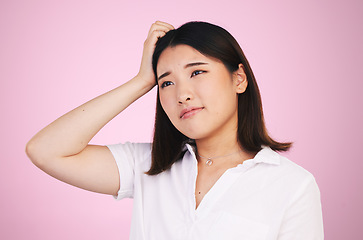 Image showing Thinking, confused and question with an asian woman on a pink background in studio for problem solving. Face, doubt or why and a young person scratching her head with a mistake, error or fail