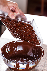 Image showing Baker pours chocolate