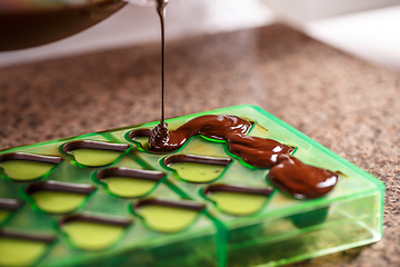 Image showing Putting chocolate in mold