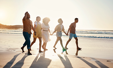 Image showing Happy, summer and friends holding hands at sunset beach for fun and travel with care. Diversity, men and women group outdoor for walk on sand with love, support and happiness on vacation or holiday