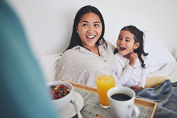 Image showing Mother and child with breakfast in bed in the bedroom for mothers day surprise at home. Happy, smile and young mom relaxing with girl kid with a healthy meal for brunch on a weekend at their house.