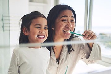 Image showing Mother, happy kid or brushing teeth in dental hygiene, morning routine or healthcare by mirror in bathroom. Mom, smile or daughter cleaning mouth in tooth whitening, oral or gum care at home together