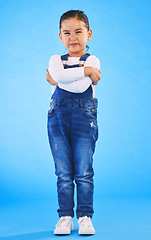 Image showing Frustrated, child and arms crossed with tantrum in studio with mockup space. Kid, young girl and angry with cross frown and rejection with youth and mad attitude with blue background and grumpy