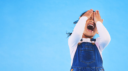 Image showing Scared, horror and kid screaming, cover face and studio isolated on a blue background mockup space. Fear, terror and scary girl child in nightmare, anxiety crisis and shouting for problem in danger