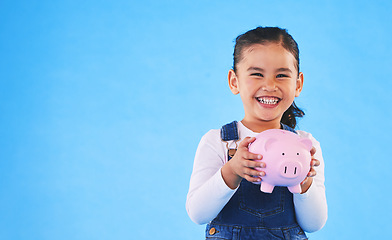 Image showing Girl kid, piggy bank and studio portrait with mockup space, saving and financial education by blue background. Female child, money box and excited for goal, investing or learning discipline with cash